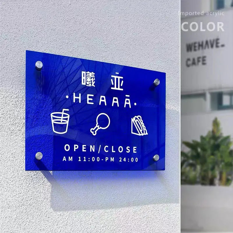 Blue sign with white text and icons on a gray wall