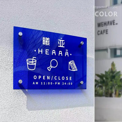 Blue sign with white text and icons on a gray wall