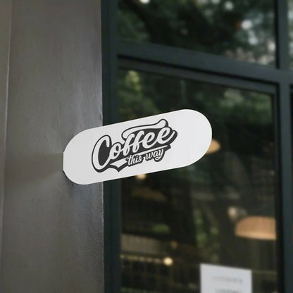 Sticker on a glass door with 'Coffee this way' text
