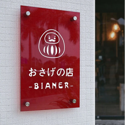 Red sign with white logo and text on a white brick wall