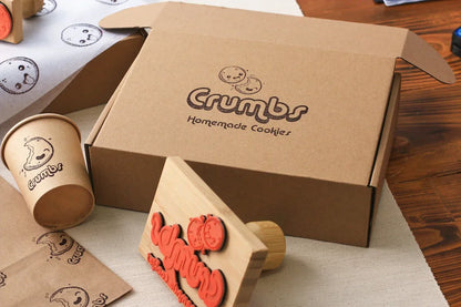Crumbs Homemade Cookies packaging with a cookie stamp on a wooden surface