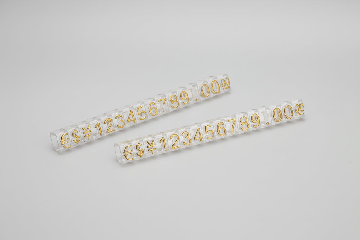 Two rolls of gold number stickers on a white background